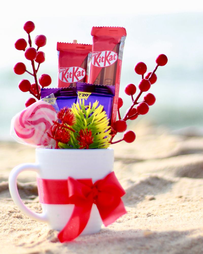 Christmas mini hamper in a white mug with chocolates and red berries, a return gift or office gift idea